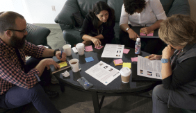 People seated on couches reviewing something together.